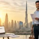 Expat job seeker standing with resume against Dubai skyline